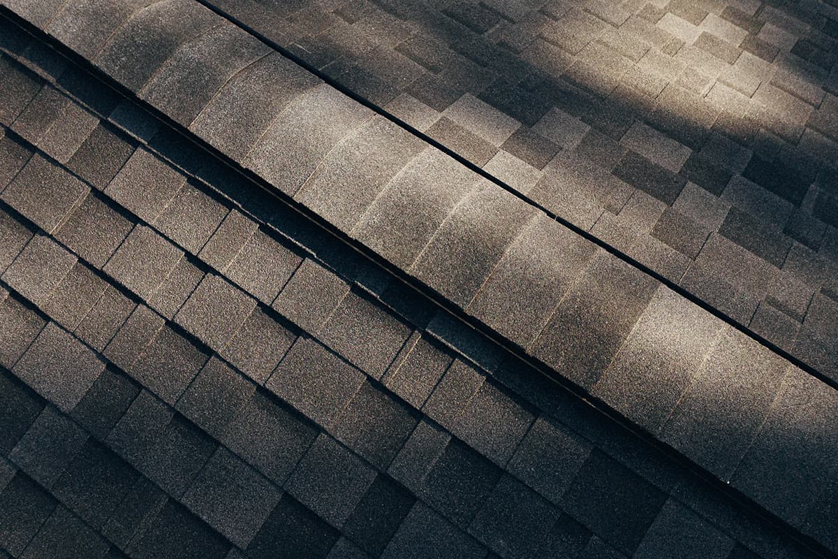 Close-up aerial view of dark asphalt roof shingles