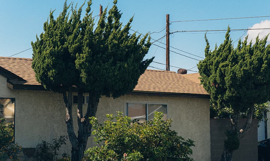 A home with an asphalt shingle roof before replacement work begins